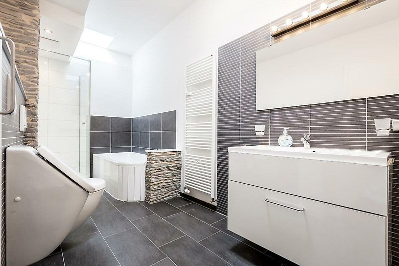 Schönes Badezimmer mit stilvoller Armatur und Glasdusche.