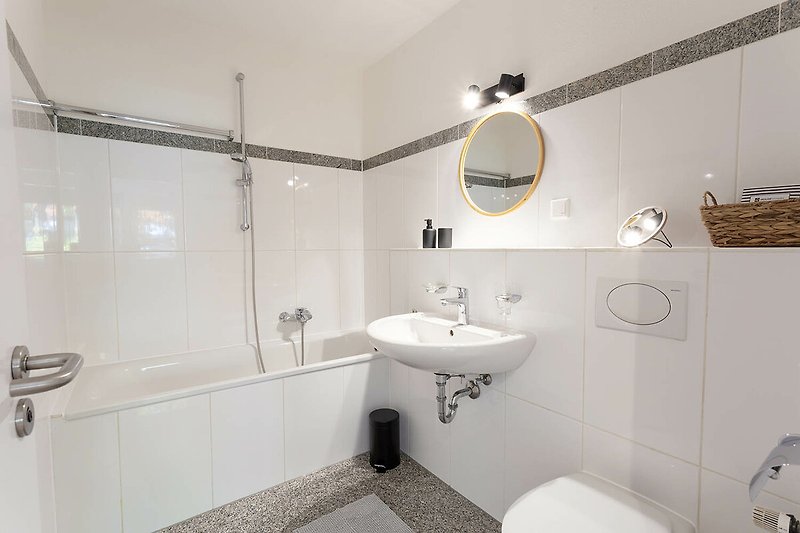 Schönes Badezimmer mit Spiegel, Waschbecken und lila Akzenten.