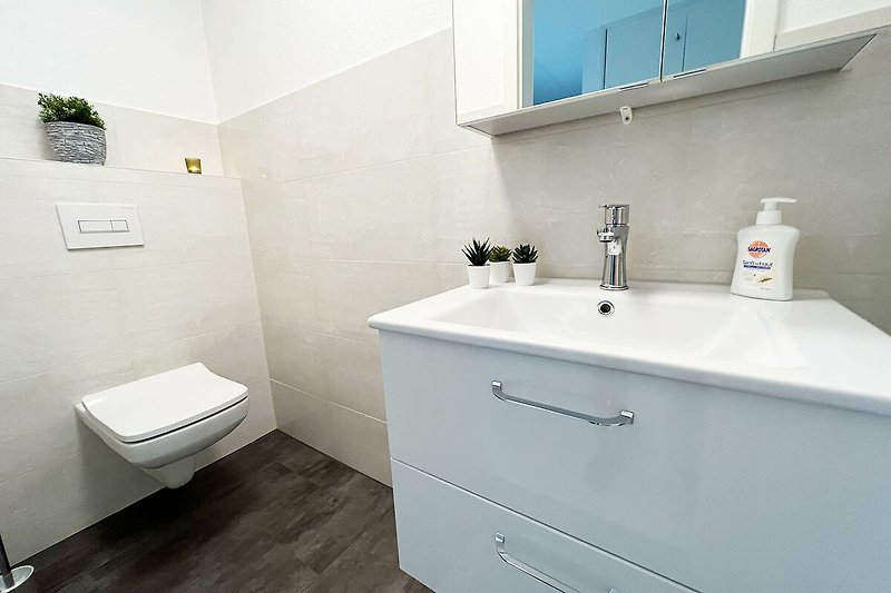 Modernes Badezimmer mit lila Waschbecken und stilvoller Armatur.
