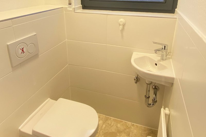 Schönes Badezimmer mit lila Wand, Holzboden und Keramikwaschbecken.