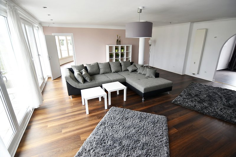 Gemütliches Wohnzimmer mit bequemen Möbeln und stilvollem Holzboden.