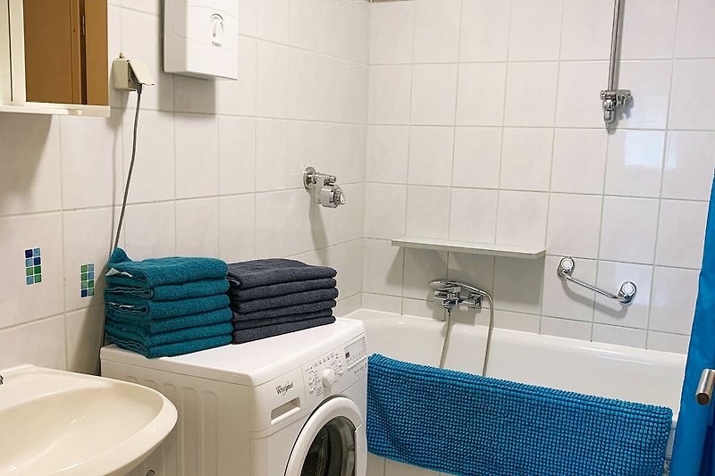 Gemütliches Badezimmer mit Waschmaschine und Trockner. Perfekt für Ihren Urlaubsaufenthalt.