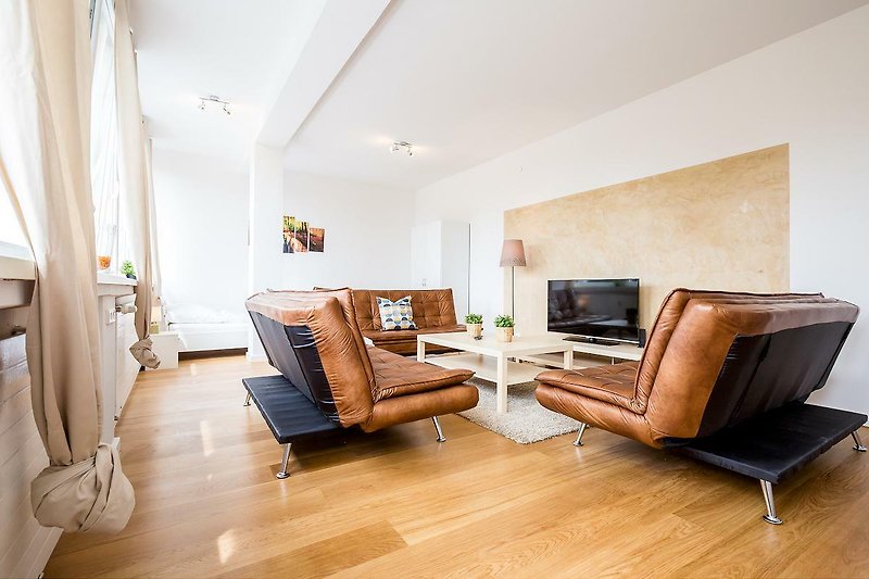 Gemütliches Wohnzimmer mit bequemen Möbeln, Holzverkleidung und Fernseher.
