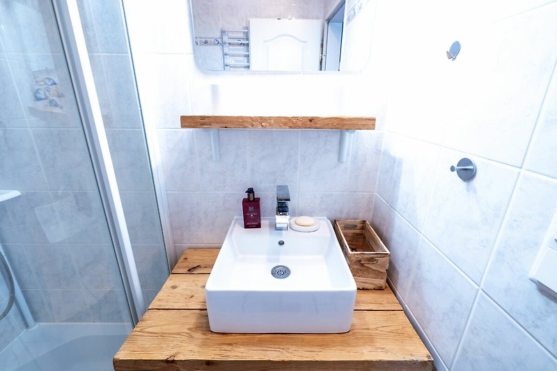 Modernes Badezimmer mit lila Akzenten, stilvoller Armatur und Waschbecken.