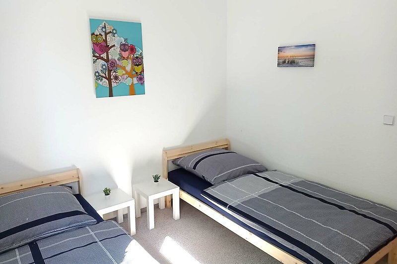 Gemütliches Schlafzimmer mit stilvollem Holzbett und Kunst an der Wand.
