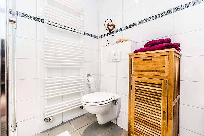Gemütliches Badezimmer mit lila Toilette, Holzboden und stilvoller Inneneinrichtung.