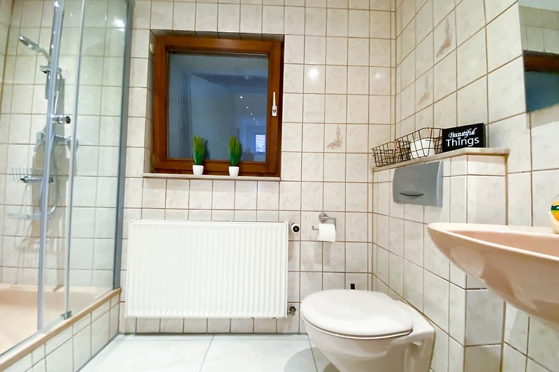 Stilvolles Badezimmer mit lila Akzenten und modernem Waschbecken.