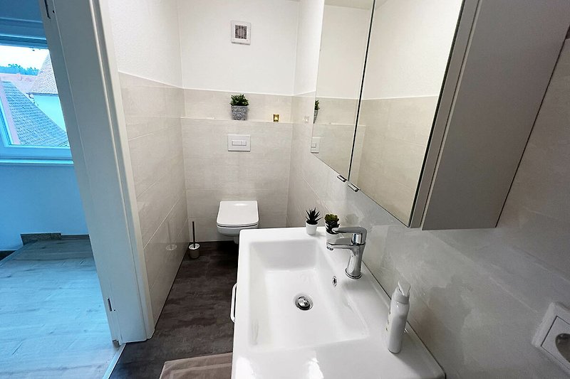 Schönes Badezimmer mit blauer Wand, Spiegel und Waschbecken.