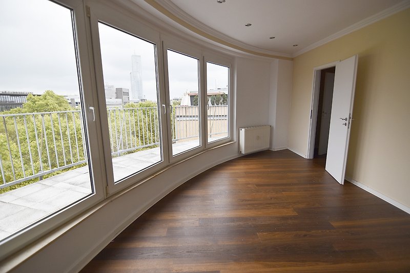 Moderne Wohnung mit stilvollem Holzboden, Glasfenstern und schöner Inneneinrichtung.