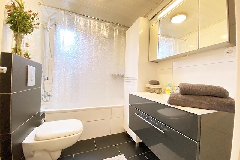 Schönes Badezimmer mit Badewanne, Dusche und stilvollem Design.