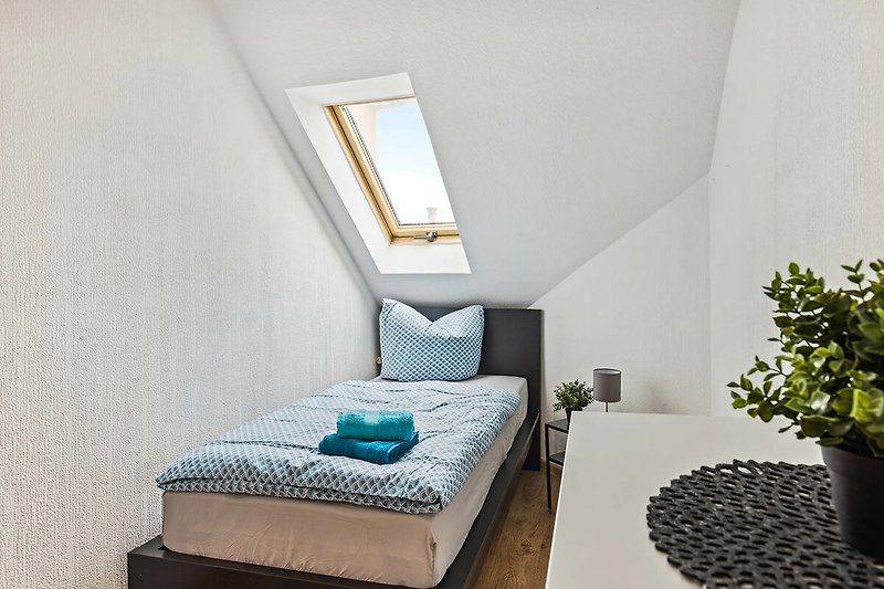 Gemütliches Schlafzimmer mit bequemem Bett, Holzmöbeln und schöner Fensterdekoration.
