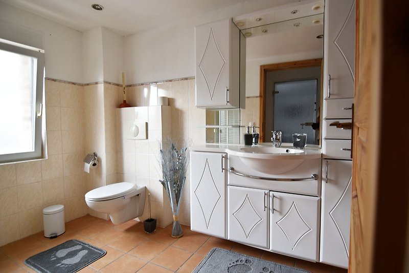 Stilvolles Badezimmer mit modernem Waschbecken und Holzmöbeln.