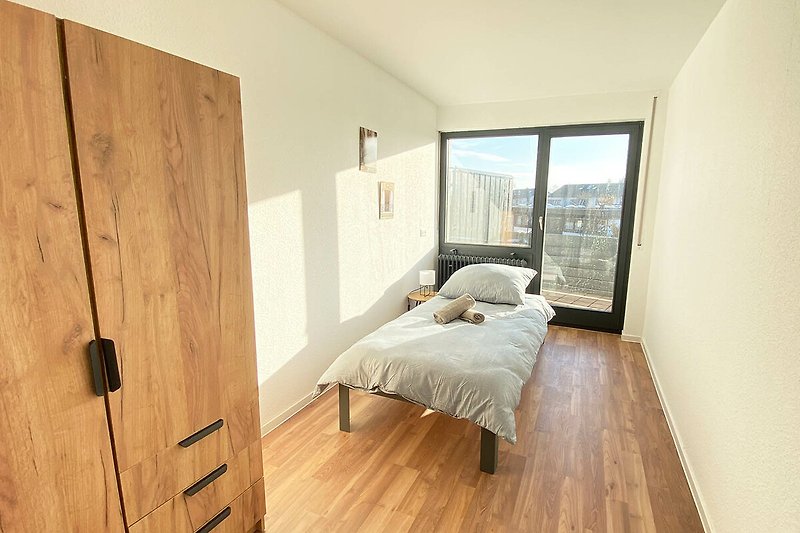 Gemütliches Schlafzimmer mit Holzbett, Fenster und stilvoller Einrichtung.