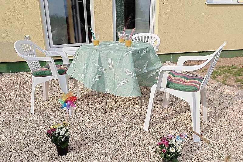 Schöner Außenbereich mit Tisch, Stühlen und Pflanzen. Ideal zum Entspannen im Freien.
