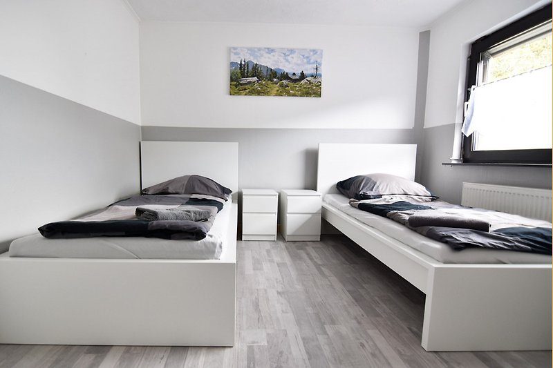 Stilvolles Schlafzimmer mit grauer Wand und Holzbett.