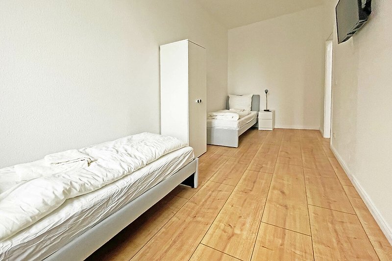 Gemütliches Schlafzimmer mit hochwertigem Holzbett und stilvoller Einrichtung.