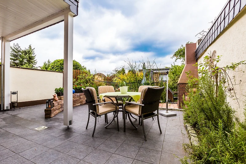 Schöne Terrasse mit Holzmöbeln und Blumentöpfen.