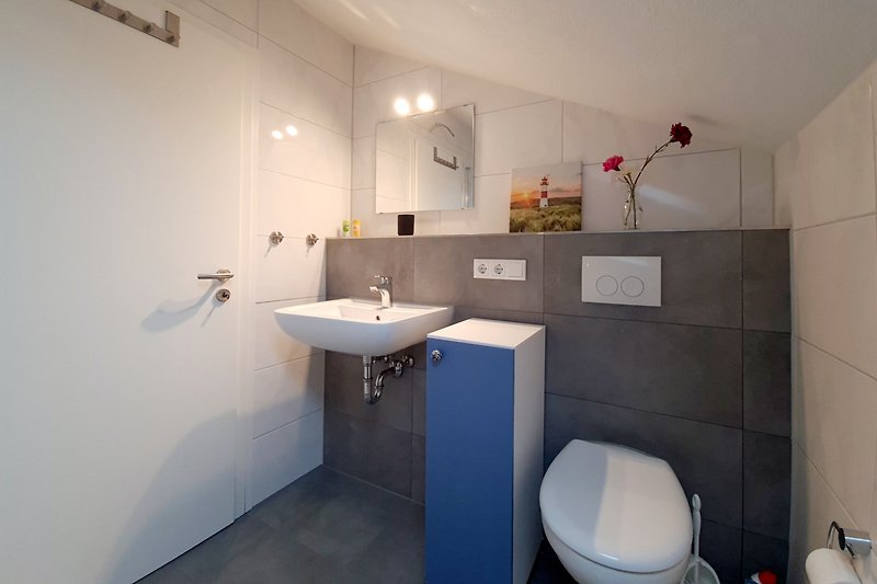 Stilvolles Badezimmer mit lila Wand, sauberem Waschbecken und elegantem Wasserhahn.