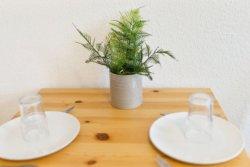Schöner Holztisch mit stilvoller Dekoration und grünen Pflanzen.