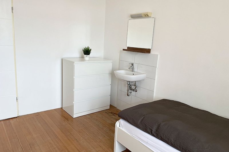 Gemütliches Badezimmer mit modernen Sanitäranlagen und Spiegel.