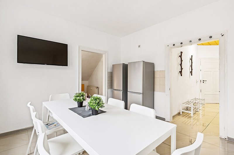 Gemütliches Wohnzimmer mit Holzmöbeln, rechteckigem Tisch und grauer Wand.