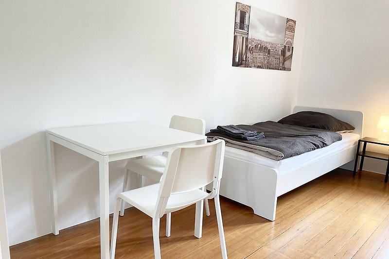 Gemütliches Schlafzimmer mit stilvollem Holzmöbel und Kunst.