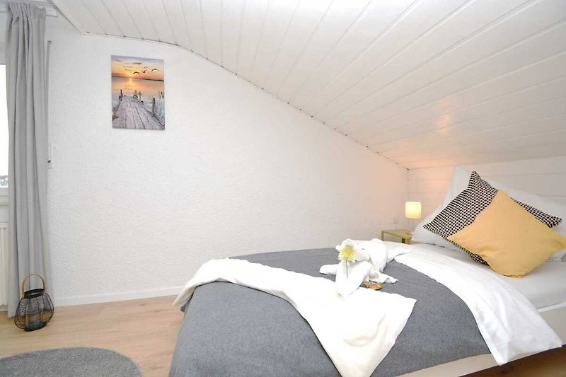 Gemütliches Schlafzimmer mit Holzbett, Textilien und gemütlicher Beleuchtung.