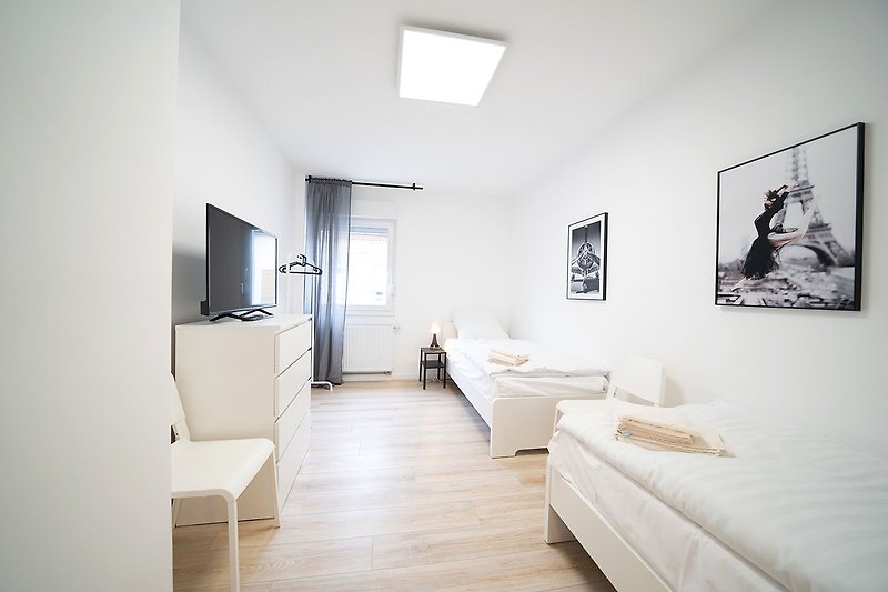 Gemütliches Ferienhaus mit stilvollem Holzboden, grauer Decke und moderner Fernseher.