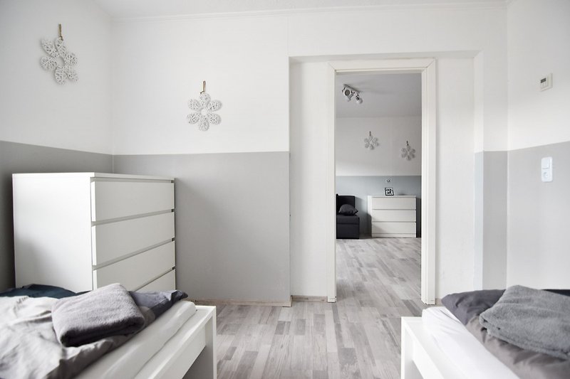 Gemütliches Schlafzimmer mit stilvollem Interieur und Holzboden.