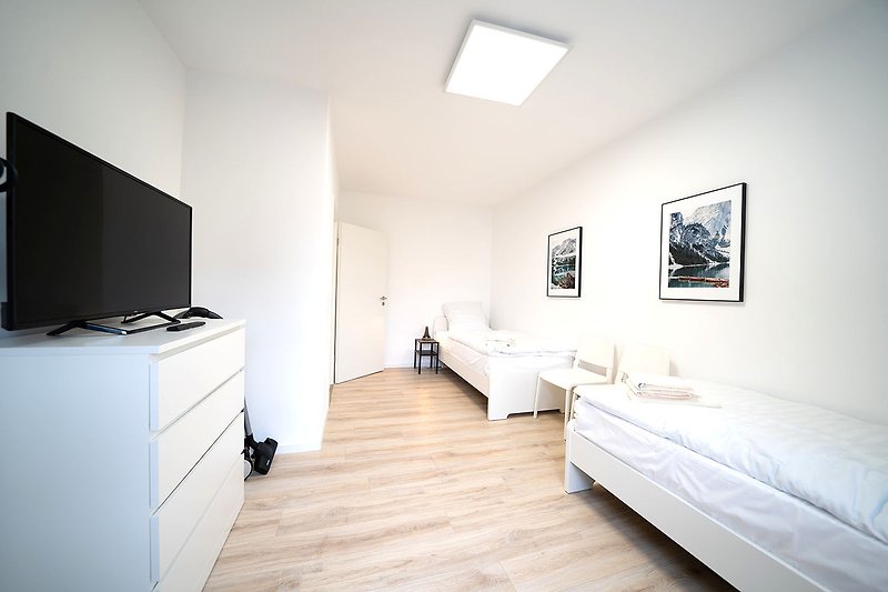 Gemütliches Schlafzimmer mit moderner Einrichtung und Holzboden.