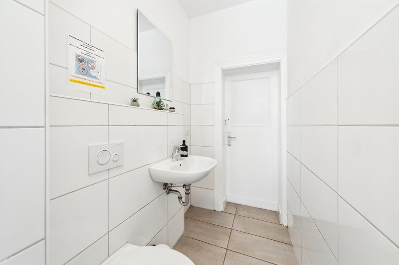 Modernes Badezimmer mit lila Waschbecken, Spiegel und Armatur.