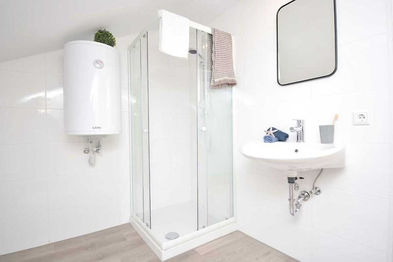 Schönes Badezimmer mit lila Waschbecken und Holzboden.