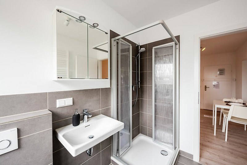 Schönes Badezimmer mit Spiegel, Waschbecken und Badewanne.