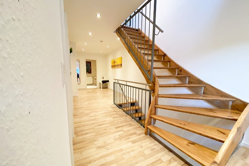 Schöne Holztreppe mit stilvollem Geländer und hochwertigem Holzstain.