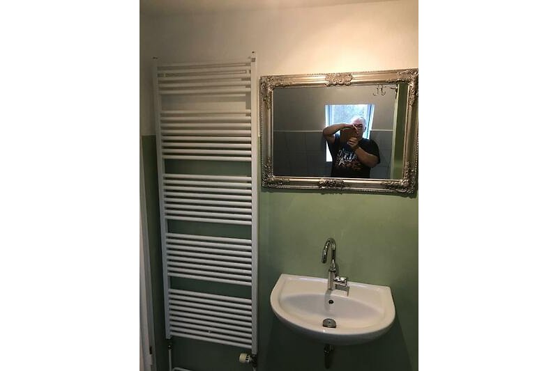 Gemütliches Badezimmer mit Spiegel, Waschbecken und stilvoller Beleuchtung.
