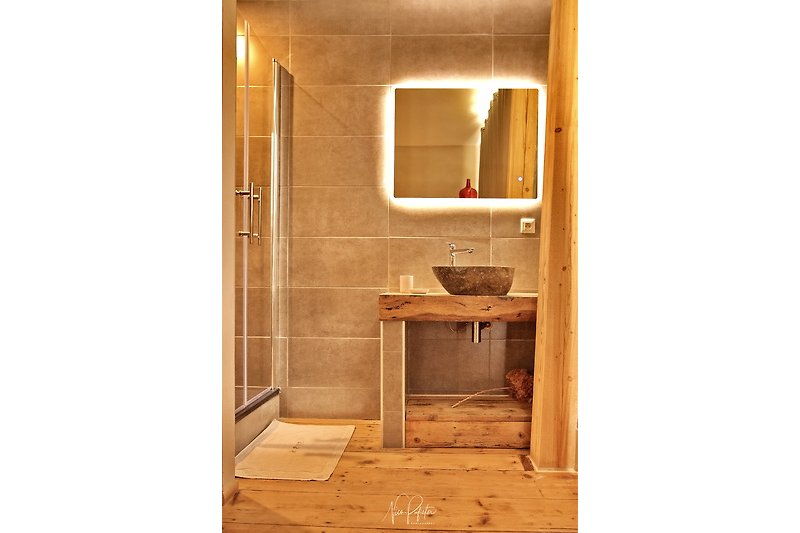 Magnifique salle de bain en bois avec douche et lavabo.