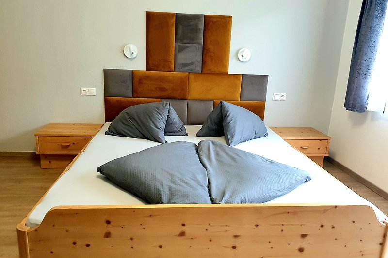 Gemütliches Schlafzimmer mit bequemem Bett, Holzmöbeln und stilvollem Interieur.