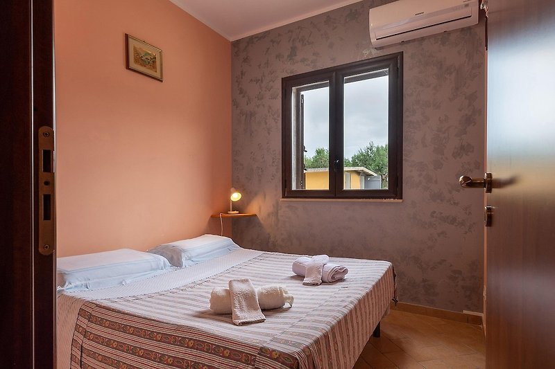 Una camera da letto accogliente con un comodo letto, arredamento in legno e una luce soffusa.