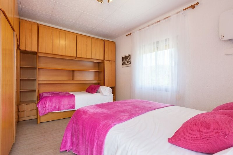 Gemütliches Schlafzimmer mit Holzmöbeln und stilvollem Bett.