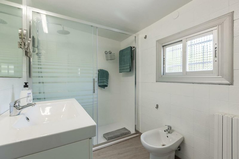 Schönes Badezimmer mit lila Beleuchtung, Spiegel und Dusche.