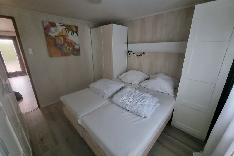 Stilvolles Schlafzimmer mit Holzbett und gemütlichen Kissen.