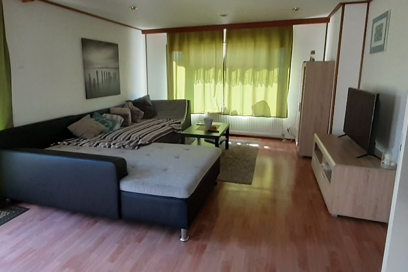 Gemütliches Wohnzimmer mit stilvollen Möbeln und Holzboden.
