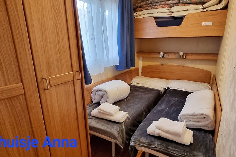 kleine slaapkamer met 2x een 1 persoonsbed en een kast