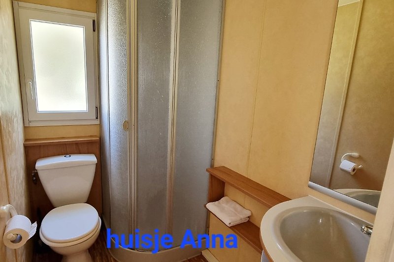 Badkamer met douchecabine, wastafelmeubel en toilet