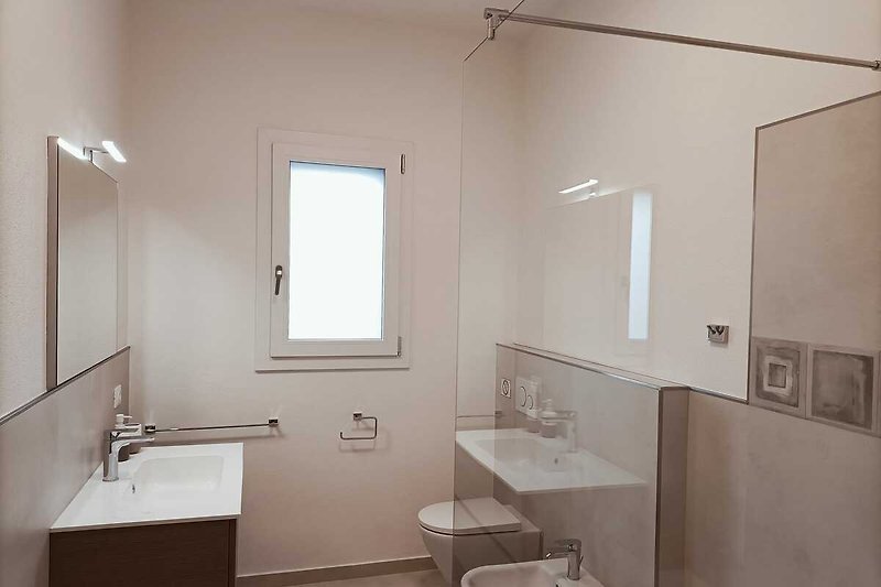 Stilvolles Badezimmer mit elegantem Spiegel, Waschbecken und stilvoller Beleuchtung.