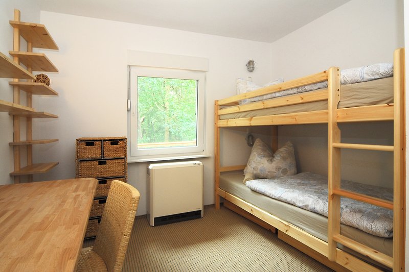 Gemütliches Schlafzimmer mit Etagenbett, Holzmöbeln und gemütlicher Einrichtung.