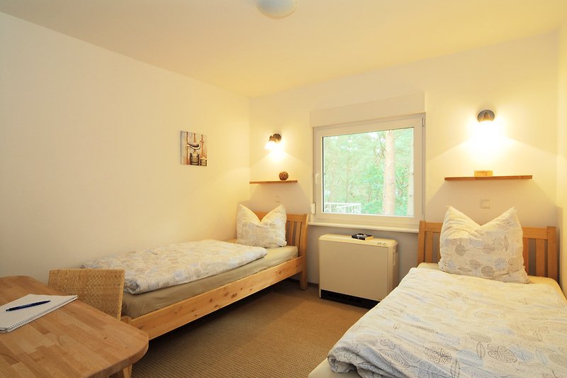Komfortables Schlafzimmer mit Holzmöbeln und großem Fenster.