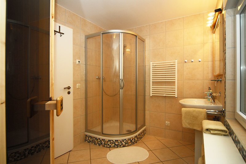 Moderne Badezimmerausstattung mit Dusche, Waschbecken und Armaturen.