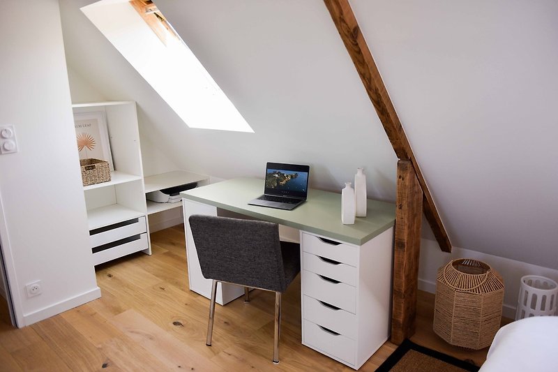 Intérieur confortable avec mobilier en bois et bureau d'ordinateur.