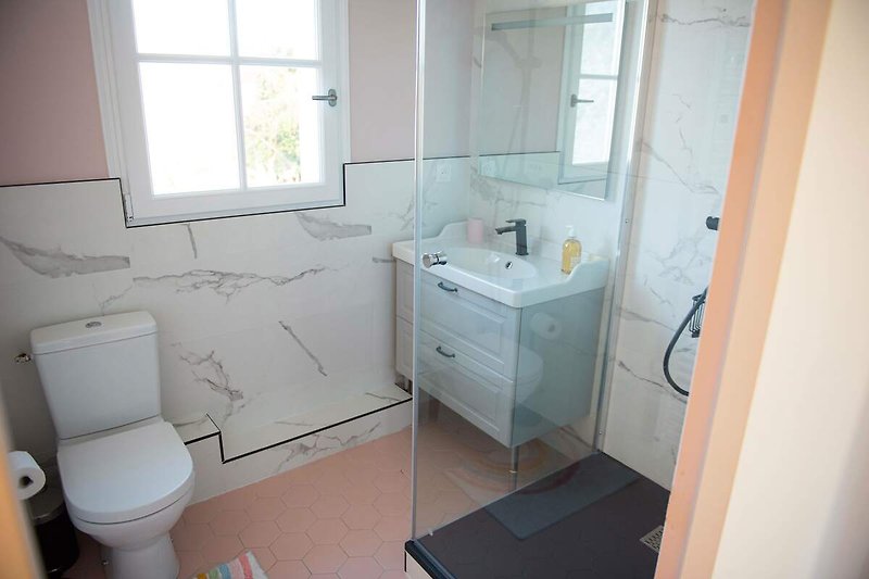 Belle salle de bain avec lavabo, robinetterie et miroir en céramique.